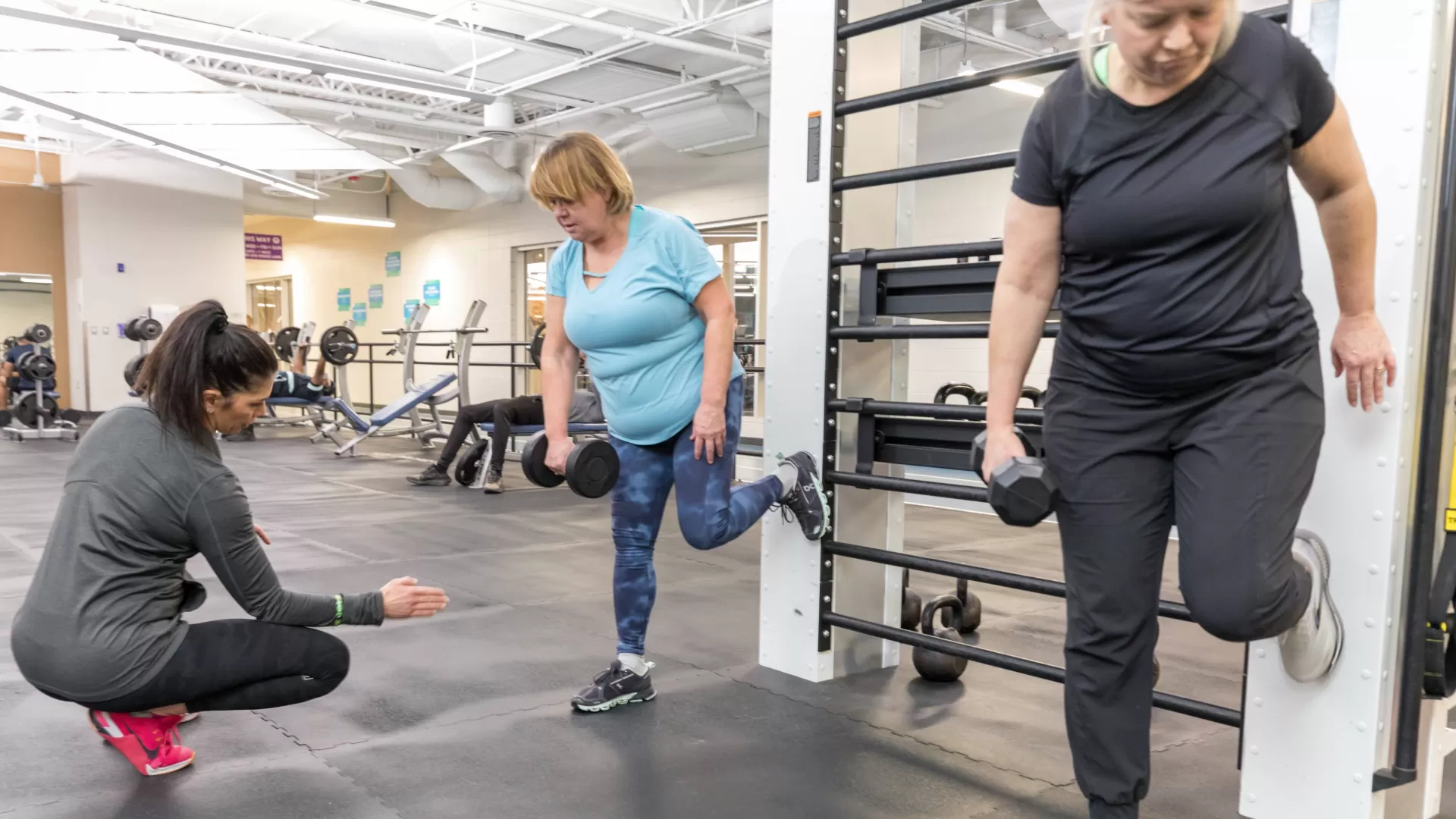 Personal trainer helping two women