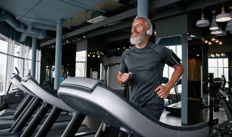 man with headphones running on a treadmill