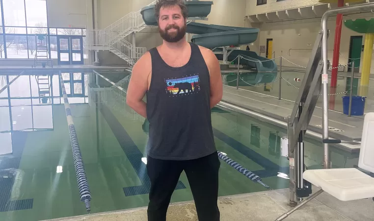 Smiling man standing in front of the pool