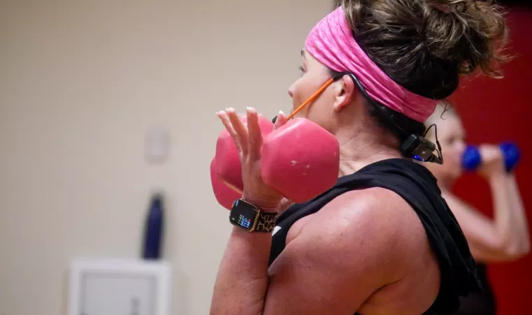 YMCA instructor lifting dumbbells