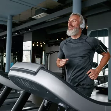 man with headphones running on a treadmill