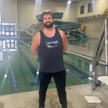 Smiling man standing in front of the pool