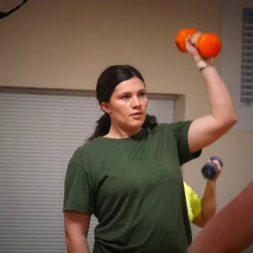 woman lifting a dumbbell over her head