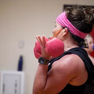 YMCA instructor lifting dumbbells